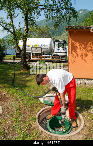 Melano, Svizzera -20 Maggio 2005: lavoratore rendendo la fornitura di gas su di un serbatoio nel giardino di una casa a Melano sulla Svizzera Foto Stock