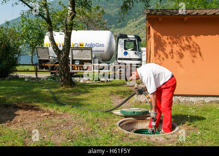 Melano, Svizzera -20 Maggio 2005: lavoratore rendendo la fornitura di gas su di un serbatoio nel giardino di una casa a Melano sulla Svizzera Foto Stock