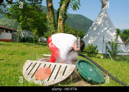 Melano, Svizzera -20 Maggio 2005: lavoratore rendendo la fornitura di gas su di un serbatoio nel giardino di una casa a Melano sulla Svizzera Foto Stock