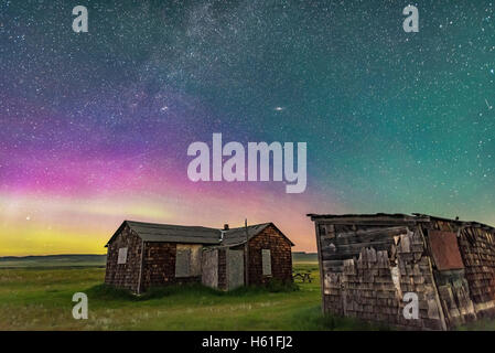 Una dim aurora a nord a praterie National Park, Saskatchewan, all'Larson Ranch sito e suo rustico pioneer cabine. Tak Foto Stock