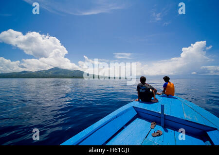 Coppia giovane seduto sulla prua di una barca di legno, Siladen Island, isola di Sulawesi, Indonesia, il sud-est asiatico Foto Stock