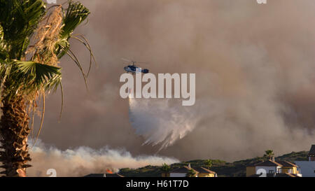 Un elicottero douses fiamme. Un elicottero scende un po' di acqua sul fuoco. Foto Stock