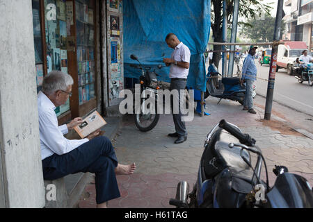 Un cliente legge un libro al di fuori di AA Hussain & Co bookstore che era stato arrestato due anni fa Foto Stock