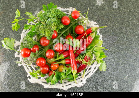 Pomodoro crudo e pepe rosso su sfondo di pietra Foto Stock