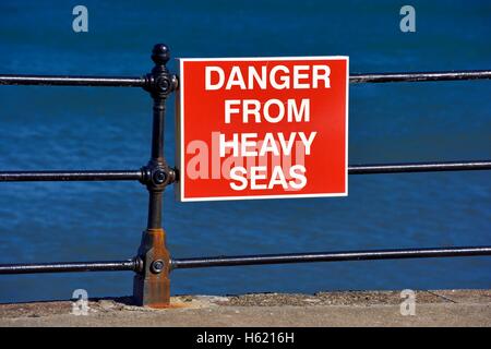 Pericolo dal mare grosso cartello sul lungomare di ringhiere in Scarborough North Yorkshire England Regno Unito Foto Stock