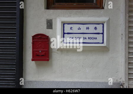 Letterbox e strada segno sia in portoghese e i caratteri cinesi Macao Cina Foto Stock