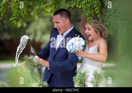 Sposa e lo sposo sul matrimonio con champagne nel verde Foto Stock