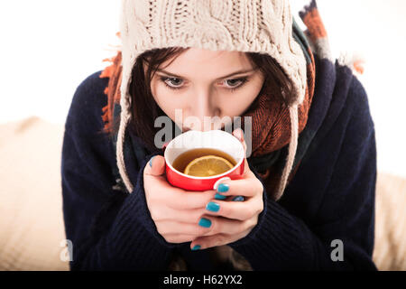 Mani femminili con bevanda calda, su sfondo chiaro Foto Stock