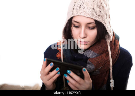 Avendo alcuni problemi. Giovane e bella capelli neri donne tenendo il telefono cellulare e lo sta guardando mentre in piedi contro uno sfondo bianco Foto Stock