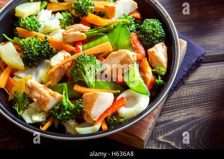 Agitare sani di verdure fritte con il pollo sul pan close up Foto Stock