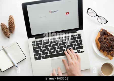 Le mani al lavoro su un notebook, bicchieri, notebook, coni, forniture per ufficio Foto Stock