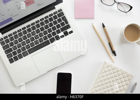 White scrivania da ufficio con gli occhiali, penna, mug, matita, bianco per notebook Foto Stock