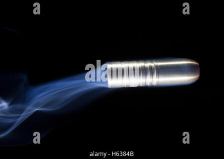 Colore rame bullet con fumo blu su sfondo nero Foto Stock