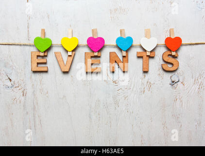 Eventi di parola delle lettere di legno su uno sfondo bianco con clothespins in legno Foto Stock