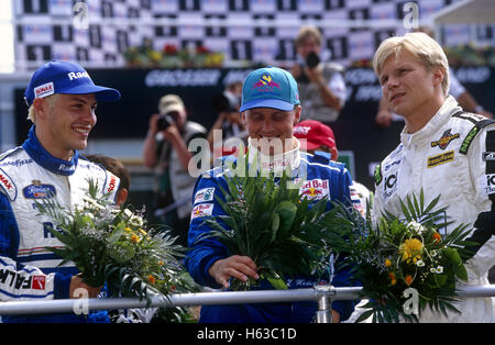 Jacques Villeneuve e Michael Schumacher, Mika Hakinnen sul podio degli anni novanta Foto Stock