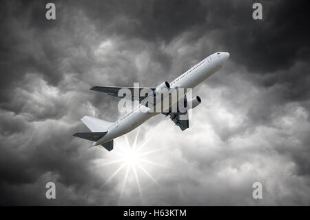 Aeroplano sopra il sole che splende da nuvole scure di tempesta sky Foto Stock