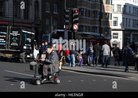 London, Regno Unito - 17 luglio, 2016. Uomo anziano drive scooter di mobilità attraverso il London street. Foto Stock