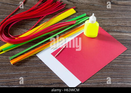 Il bambino creare biglietti di auguri di carta origami miele e Garnett ramo di albero su un tavolo di legno. Fabbricazione di carta origami grena Foto Stock