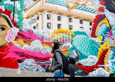 San Francisco, CA, USA, Chinese Woman Walking Past Street Art, Public Mural Painting (credito dell'artista: Melwaters), Chinatown quartiere cinese locale Foto Stock