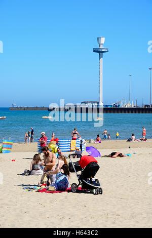 I turisti sulla spiaggia con la Jurassic Skyline tower per la parte posteriore di Weymouth Dorset, Inghilterra, Regno Unito, Europa occidentale. Foto Stock