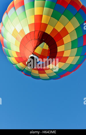 Una mongolfiera in salita con un luminoso cielo blu Foto Stock