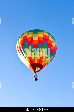 Una mongolfiera in salita con un luminoso cielo blu Foto Stock