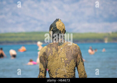 Persona non riconoscibile in sana fango sulla spiaggia torna portret view Foto Stock