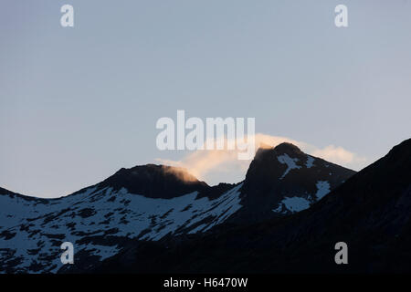 Le montagne circondano questo piccolo villaggio di Sildpollnes, Austvagoy, Lofoten Islands, Norvegia. Sole di mezzanotte in primavera. Foto Stock