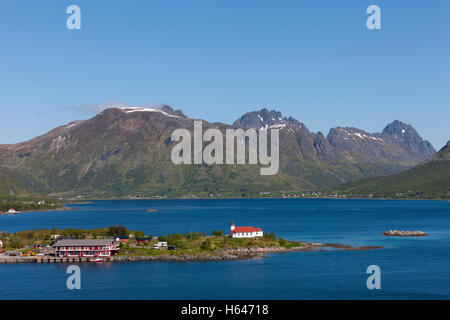 Le montagne circondano questo piccolo villaggio di Sildpollnes, Austvagoy, Lofoten Islands, Norvegia. Sole di mezzanotte in primavera. Foto Stock