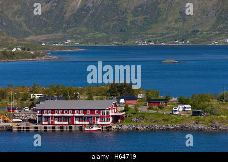 Le montagne circondano questo piccolo villaggio di Sildpollnes, Austvagoy, Lofoten Islands, Norvegia. Sole di mezzanotte in primavera. Foto Stock