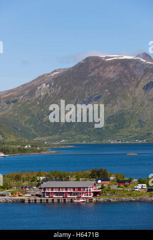 Le montagne circondano questo piccolo villaggio di Sildpollnes, Austvagoy, Lofoten Islands, Norvegia. Sole di mezzanotte in primavera. Foto Stock