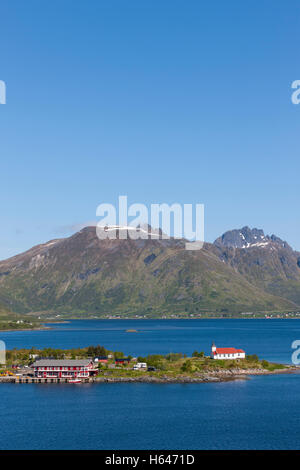 Le montagne circondano questo piccolo villaggio di Sildpollnes, Austvagoy, Lofoten Islands, Norvegia. Sole di mezzanotte in primavera. Foto Stock