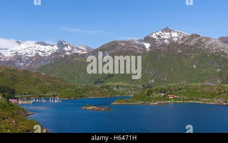 Le montagne circondano questo piccolo villaggio di Sildpollnes, Austvagoy, Lofoten Islands, Norvegia. Sole di mezzanotte in primavera. Foto Stock