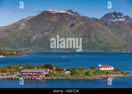 Le montagne circondano questo piccolo villaggio di Sildpollnes, Austvagoy, Lofoten Islands, Norvegia. Sole di mezzanotte in primavera. Foto Stock