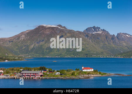 Le montagne circondano questo piccolo villaggio di Sildpollnes, Austvagoy, Lofoten Islands, Norvegia. Sole di mezzanotte in primavera. Foto Stock