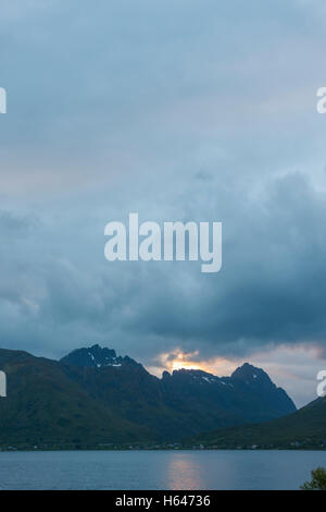 Le montagne circondano questo piccolo villaggio di Sildpollnes, Austvagoy, Lofoten Islands, Norvegia. Sole di mezzanotte in primavera. Foto Stock