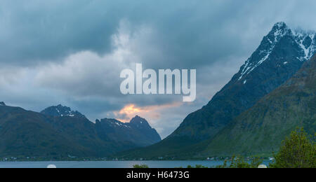 Le montagne circondano questo piccolo villaggio di Sildpollnes, Austvagoy, Lofoten Islands, Norvegia. Sole di mezzanotte in primavera. Foto Stock