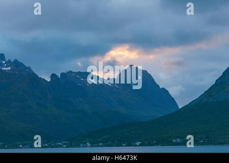 Le montagne circondano questo piccolo villaggio di Sildpollnes, Austvagoy, Lofoten Islands, Norvegia. Sole di mezzanotte in primavera. Foto Stock