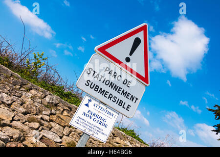 Segnale di avvertimento su Noirmoutier, Francia scalo per il parcheggio di un solo lato e soggette ad inondazioni Foto Stock