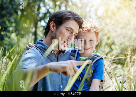 Padre figlio mostrando una grasshopper Foto Stock