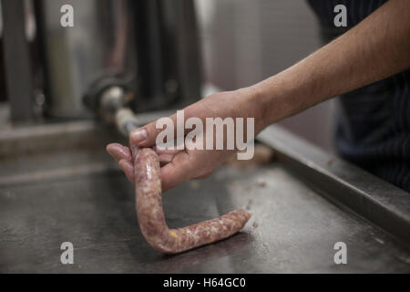 Butcher preparare le salsicce in macelleria Foto Stock