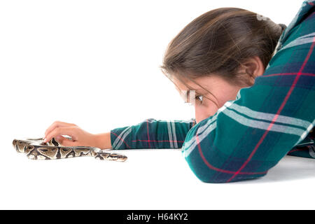 Ragazza che gioca con un serpente isolato in bianco Foto Stock