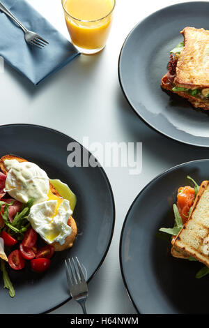 La colazione del mattino - molti panini, benedetto uova, bacon, succo di frutta e verdura Foto Stock