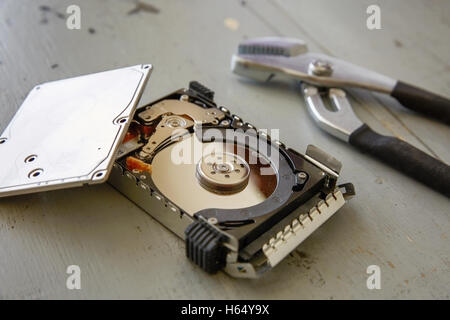 Rotto e distrutto unità disco rigido su un tavolo di legno. Foto Stock
