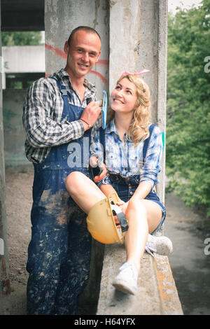 Una coppia di giovani lavoratori in una casa di nuova costruzione vicino alla finestra. Foto Stock