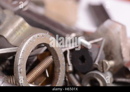 Grande pila di metallo screwbolts filettato i dadi e le rondelle del bullone su sfondo metallico concetto costruttivo. Foto Stock