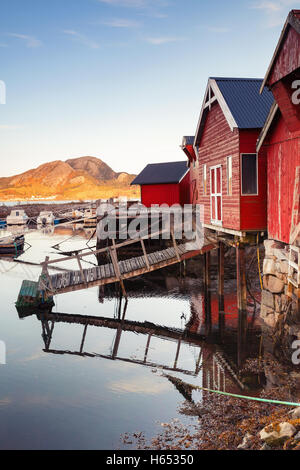 Foto verticale di rosso norvegese fienili in legno permanente sulla costa del mare. Snillfjord, regione Sor-Trondelag, pesca Vingvagen vill Foto Stock