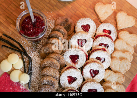 Pasticceria e biscotti presentato su una tavola di legno con ingredienti accanto ad esso Foto Stock