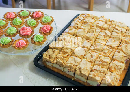 Un formaggio la torta su un piatto e muffin, tortine decorate Foto Stock