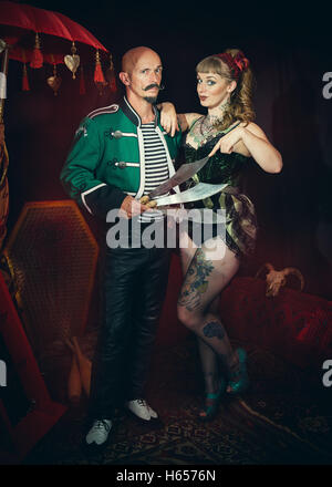 Artisti del circo vestito per agire, uno rivolto a spade Foto Stock